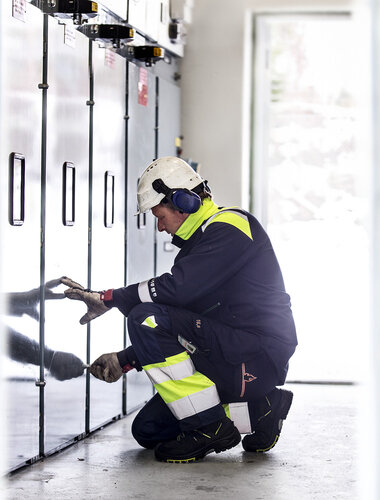 Werkende elektricien in vlamvertragende werkkleding