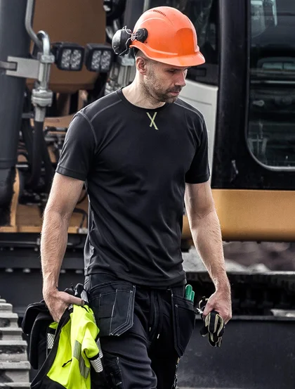Man op de bouw in T-shirst met een sweatjack in de hand