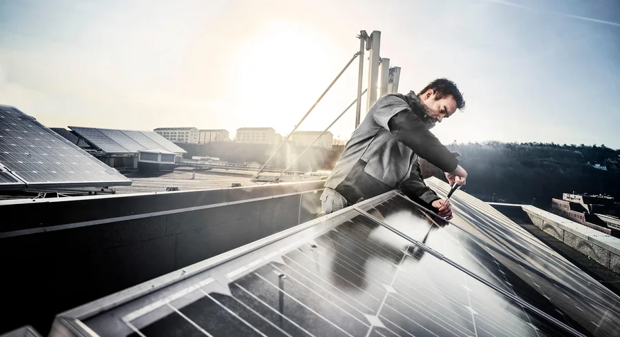 In ecologische werkkleding voor de bouw installeert deze man zonnepanelen - Fristads Green collectie