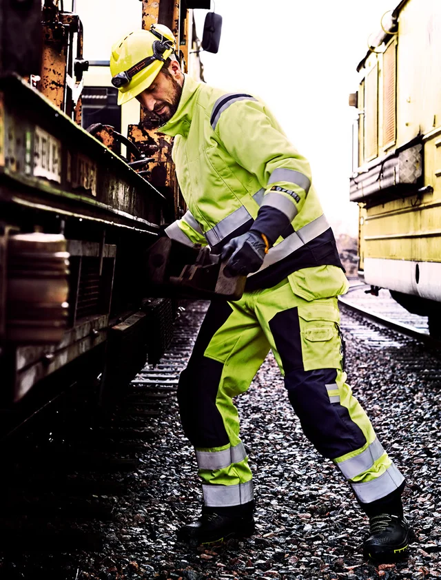 Man aan het werk aan een trein in vlamvertragende werkkleding