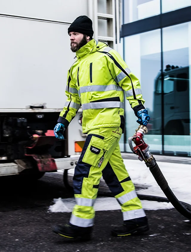 man bij vrachtwagen in vlamvertragende werkkleding