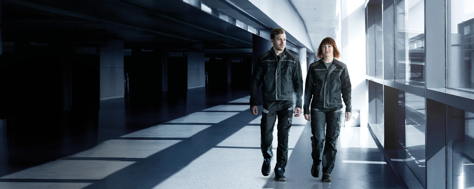 Homme et dame qui portent Fristads Fusion