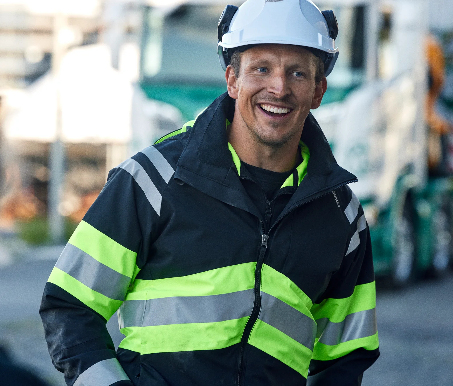 Cran truck driver driver wearing a yellow/black high-visibility jacket and work trousers from Fristads.