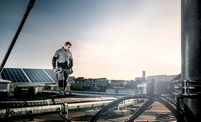 Fristads Green gedragen door een man op een dak met zonnepanelen